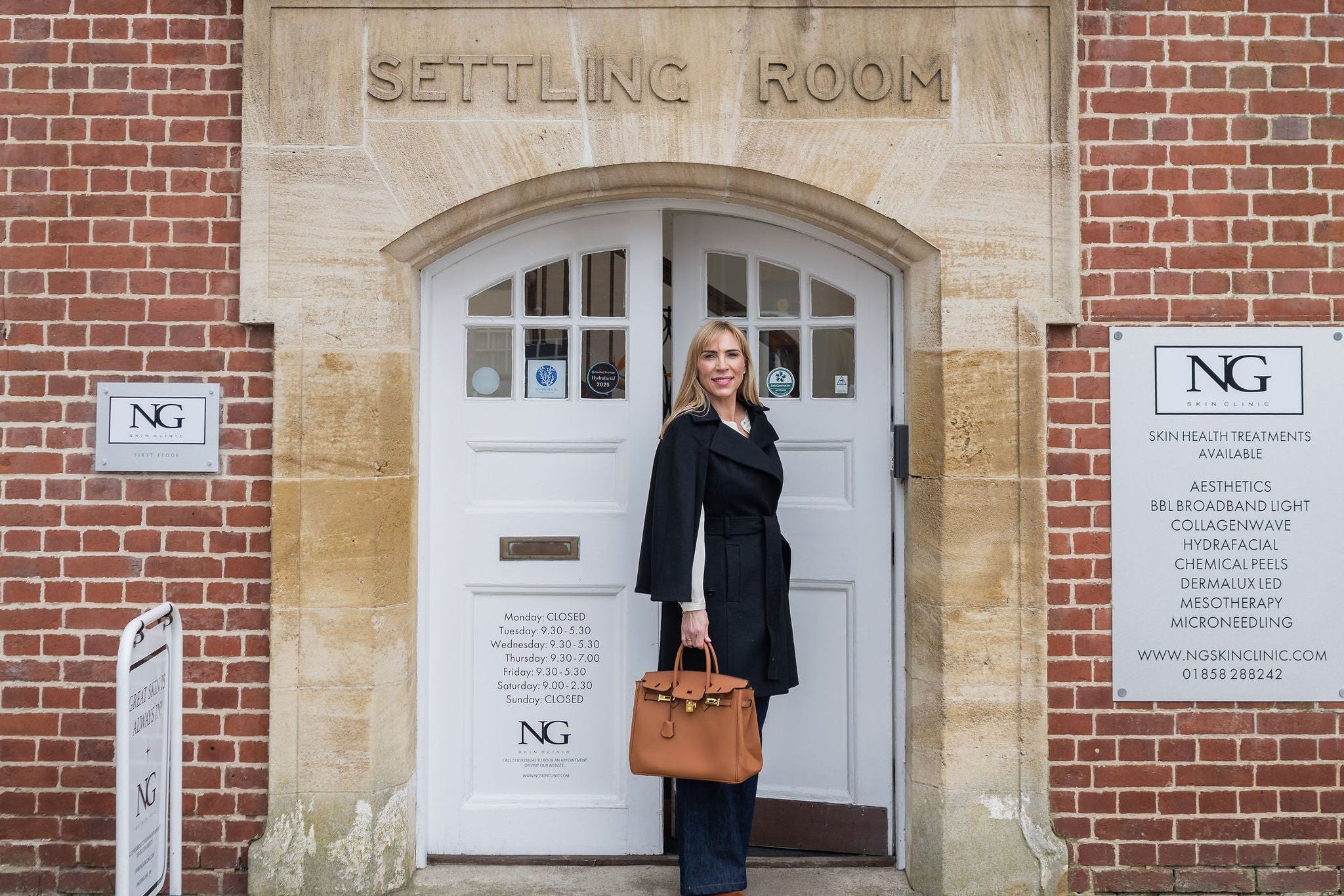 Woman standing in front of a brick building with 'Settling Room' signage